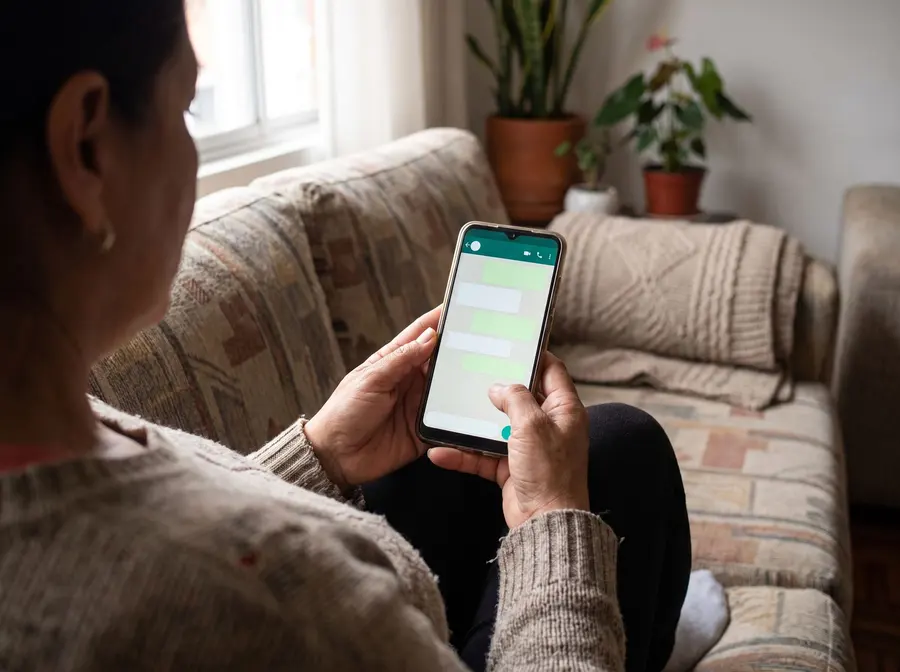 Cliente escribiendo por WhatsApp desde el sofá de su casa